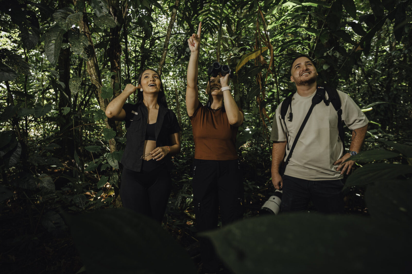 Visitors watching wild birds with binoculars on a La Fortuna nature tour