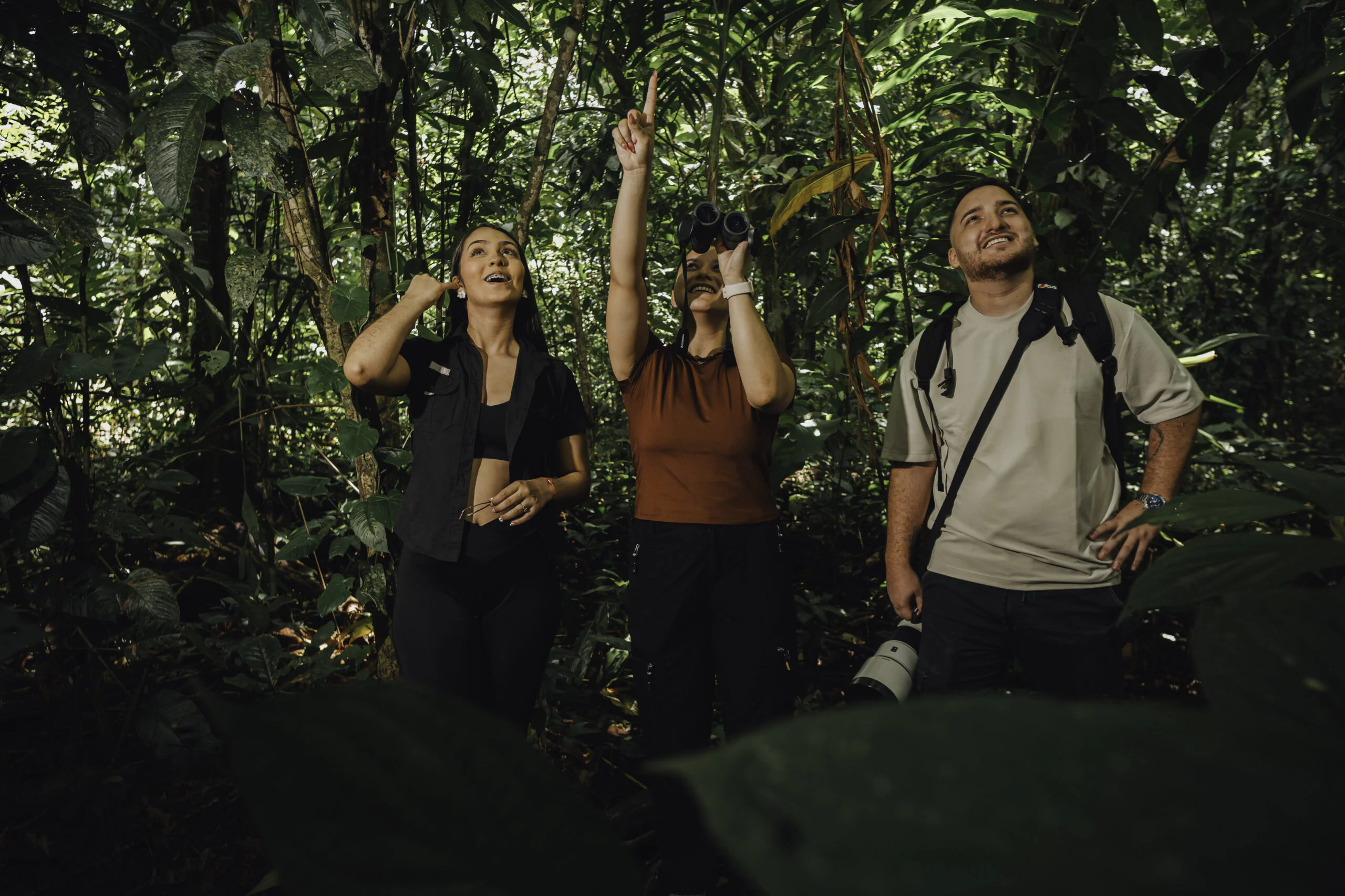 Visitors watching wild birds with binoculars on a La Fortuna nature tour
