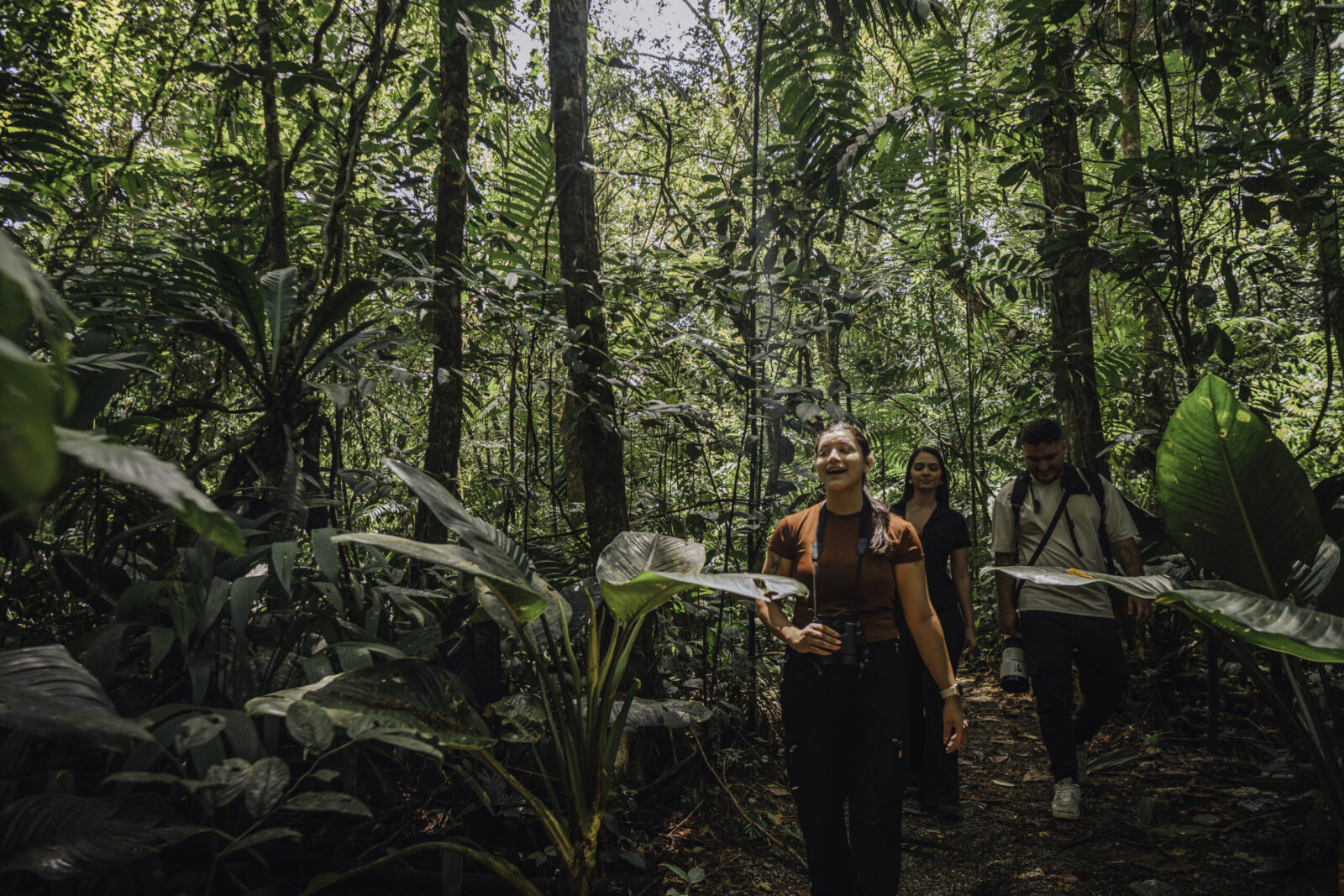 Group of travelers walking along a shaded forest trail in Arenal